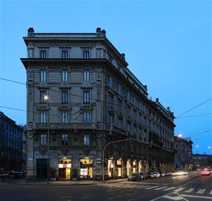 Exterior photo of the illuminated windows of Sag80, a design store located in Via Boccacio